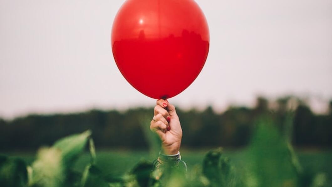 Rode ballon boven groen veld
